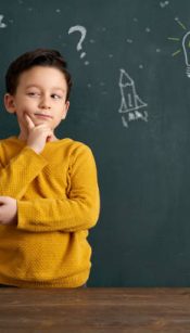 6-7 years old cute child standing front of blackboard