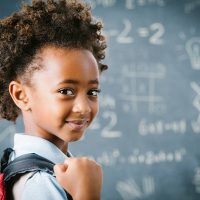 Cute little African school girl in classroom.